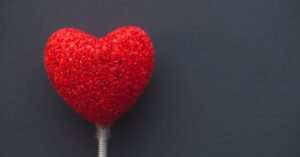 A vibrant red heart on a dark backdrop, symbolizing love and romance.