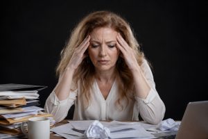 Person experiencing emotional burnout feeling mentally exhausted, stressed, and overwhelmed while sitting alone indoors.